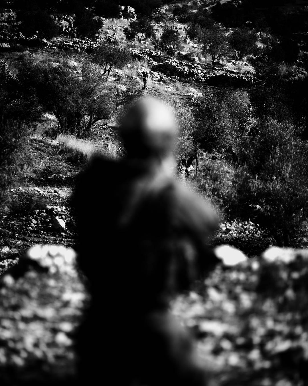 Taking aim at a protestor seen just above his helmet, but not firing, an IDF soldier seeks to quiet a crowd of protestor